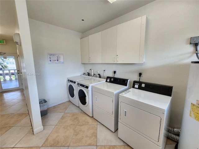 laundry area with separate washer and dryer, light tile patterned floors, gas water heater, and cabinets