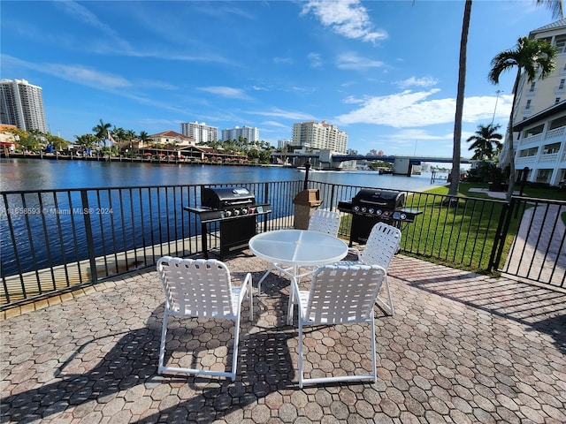 view of patio with grilling area and a water view