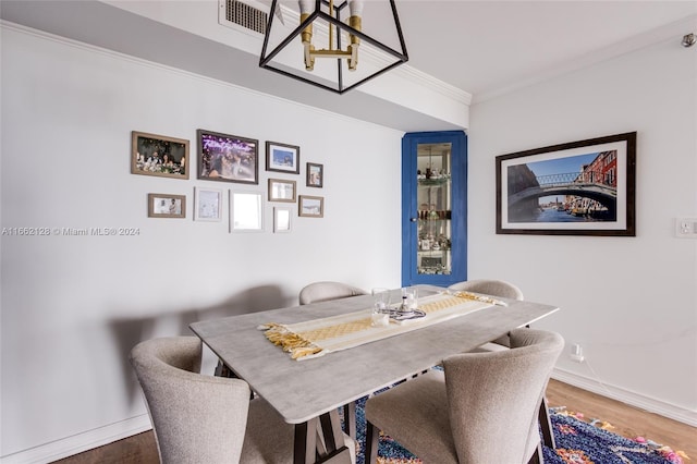 dining area featuring crown molding and hardwood / wood-style flooring