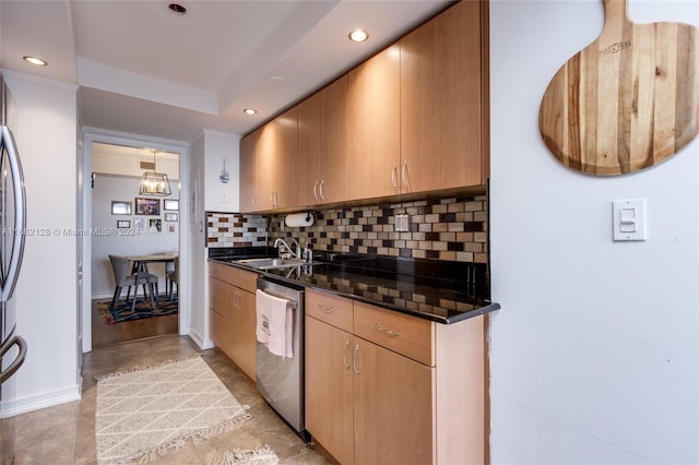 kitchen featuring dark stone counters, sink, backsplash, decorative light fixtures, and stainless steel dishwasher