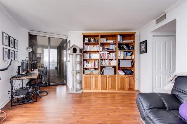 office space with ornamental molding and light hardwood / wood-style floors