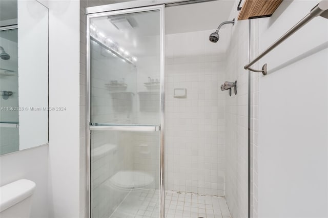 bathroom featuring walk in shower and toilet