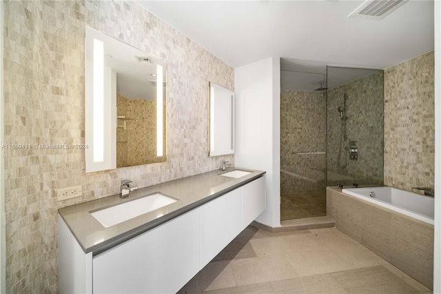 bathroom featuring independent shower and bath, vanity, tile walls, and tile patterned floors