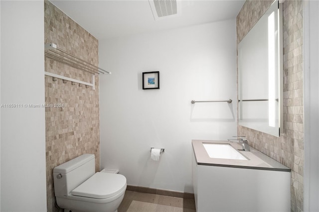 bathroom featuring vanity, tile walls, and toilet