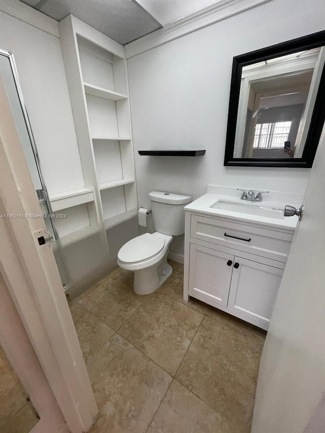 bathroom with vanity, toilet, and tile patterned flooring