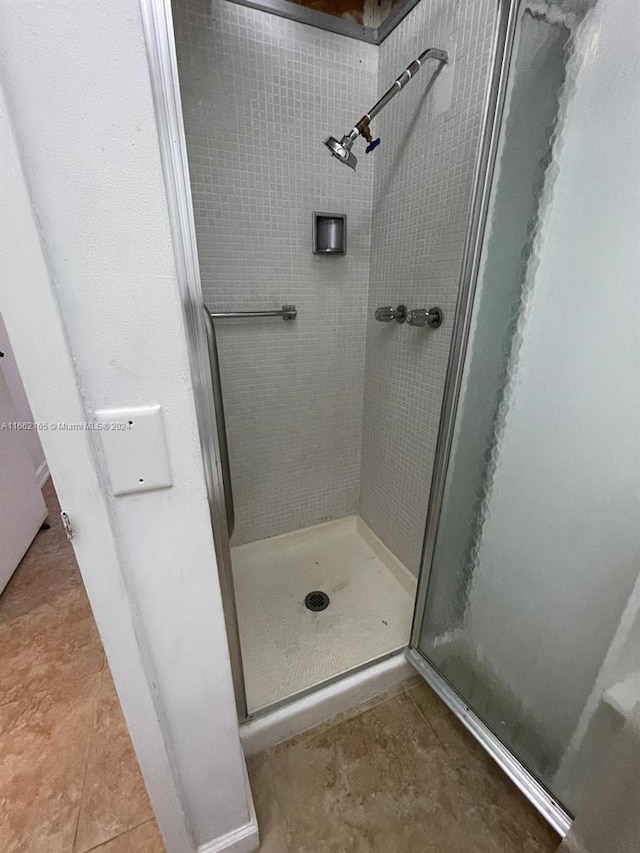 bathroom featuring a shower with door and tile patterned floors