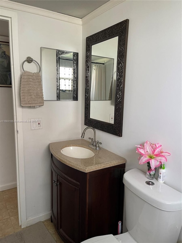 bathroom with vanity, toilet, crown molding, and tile patterned floors