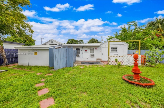 back of property featuring a storage shed and a lawn