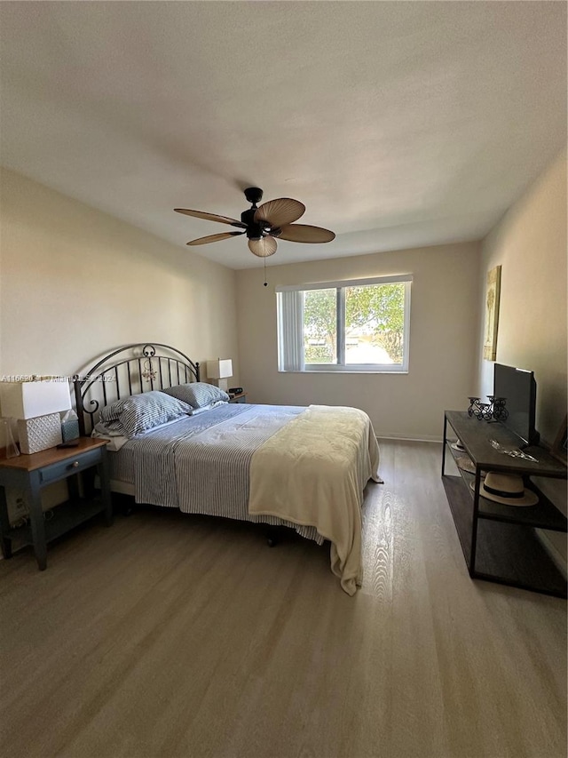 bedroom with a textured ceiling, ceiling fan, and hardwood / wood-style flooring