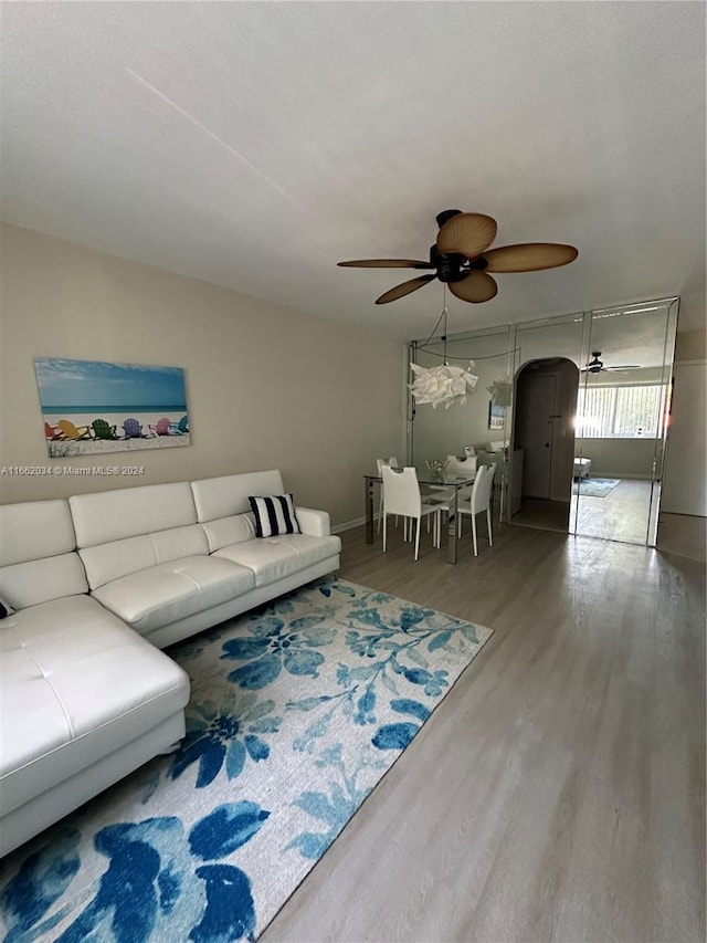 living room featuring ceiling fan and hardwood / wood-style flooring