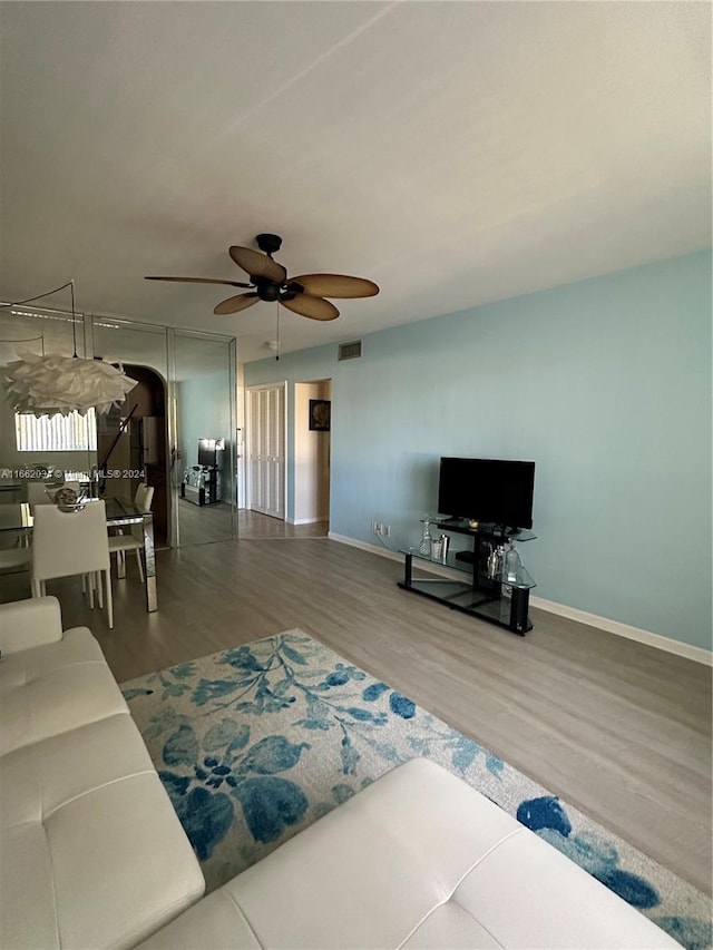 living room featuring ceiling fan and hardwood / wood-style flooring