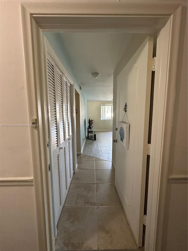 hallway with dark tile patterned floors