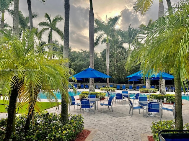 pool at dusk with a patio area