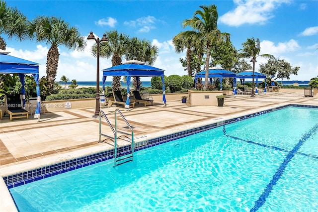 view of pool with a water view, a gazebo, and a patio area