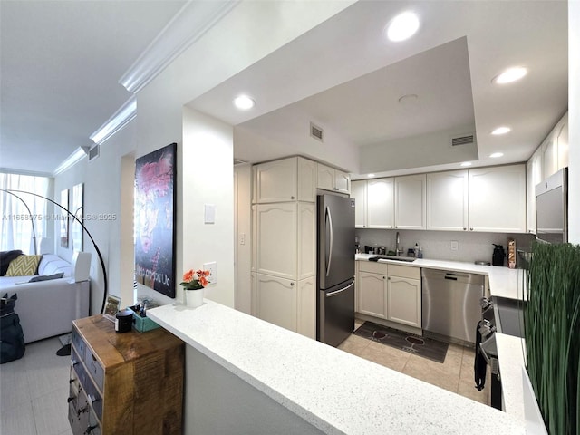 5600 Collins Ave Unit 15B, Miami Beach, FL 33140 - kitchen with appliances with stainless steel finishes, recessed lighting, crown molding, light tile patterned floors, and decorative backsplash