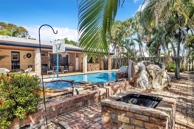 view of pool featuring an in ground hot tub, an outdoor fire pit, and a patio area