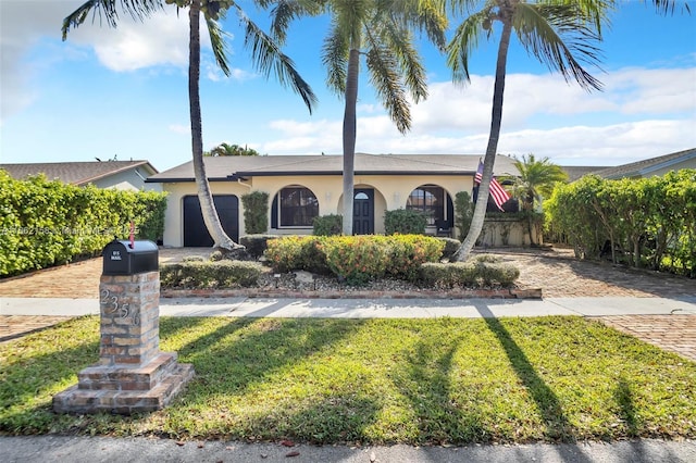 ranch-style house featuring a front yard and a garage