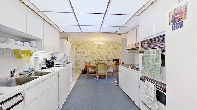 kitchen with white cabinets, sink, a notable chandelier, decorative light fixtures, and dishwasher