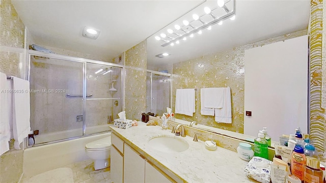 full bathroom with tile patterned flooring, combined bath / shower with glass door, vanity, and toilet