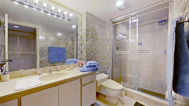 bathroom featuring an enclosed shower, vanity, and toilet