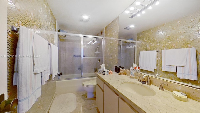 full bathroom with vanity, tile patterned flooring, combined bath / shower with glass door, and toilet