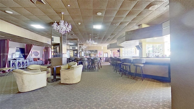 interior space featuring a drop ceiling and an inviting chandelier