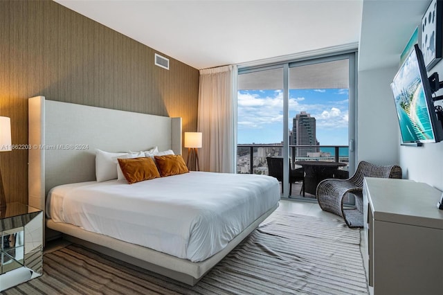 bedroom with visible vents, floor to ceiling windows, wallpapered walls, and access to outside