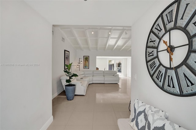 hall featuring beam ceiling and light tile patterned floors