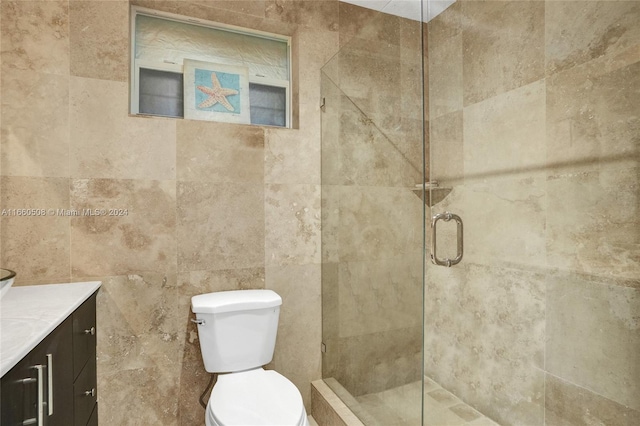 bathroom featuring vanity, tile walls, toilet, and an enclosed shower