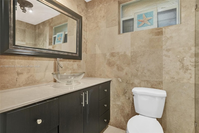 bathroom featuring tile walls, vanity, and toilet