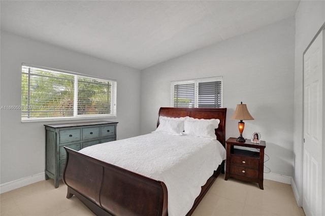 tiled bedroom featuring lofted ceiling