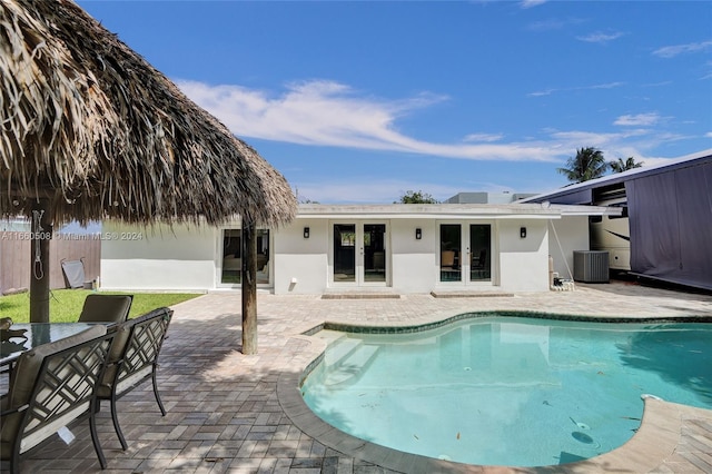 view of swimming pool with a patio area and central air condition unit