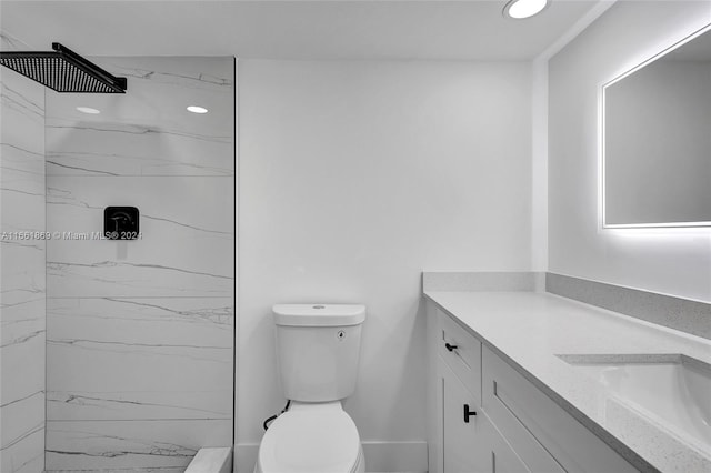 bathroom featuring tiled shower, vanity, and toilet