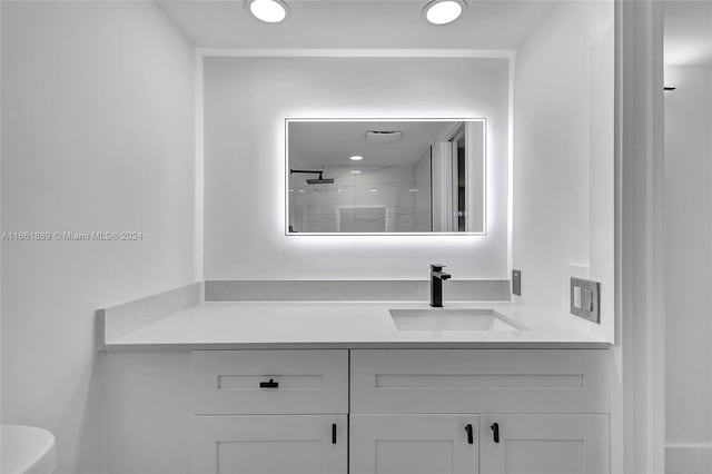 bathroom featuring walk in shower, vanity, and toilet