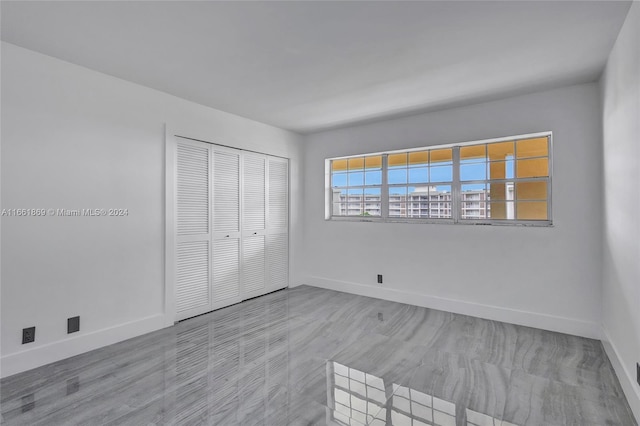 unfurnished bedroom with light hardwood / wood-style flooring and a closet