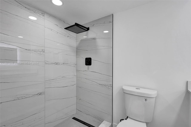 bathroom with tiled shower and toilet