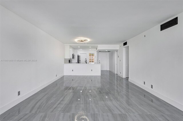 unfurnished living room featuring sink