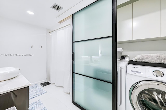 laundry area featuring washing machine and dryer and light tile patterned flooring