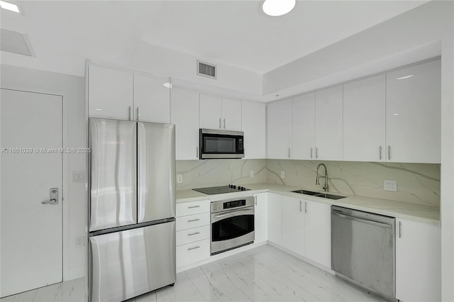 kitchen with tasteful backsplash, visible vents, marble finish floor, stainless steel appliances, and a sink