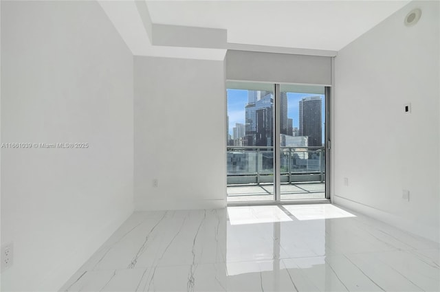 unfurnished room with a city view and marble finish floor