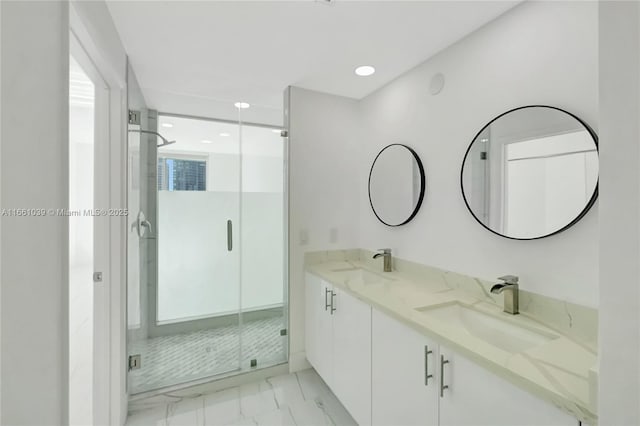 bathroom with double vanity, a stall shower, marble finish floor, and a sink