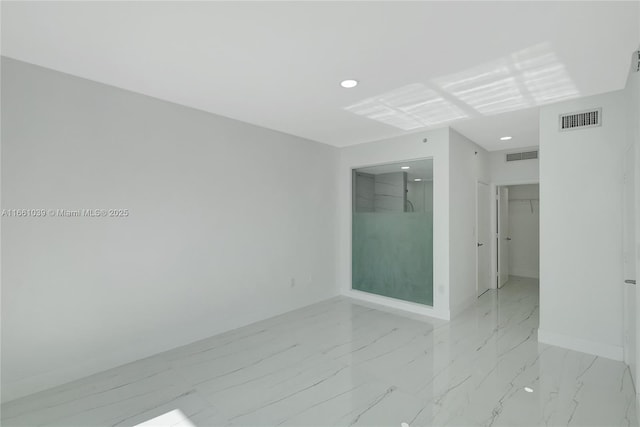 unfurnished room featuring baseboards, visible vents, and marble finish floor