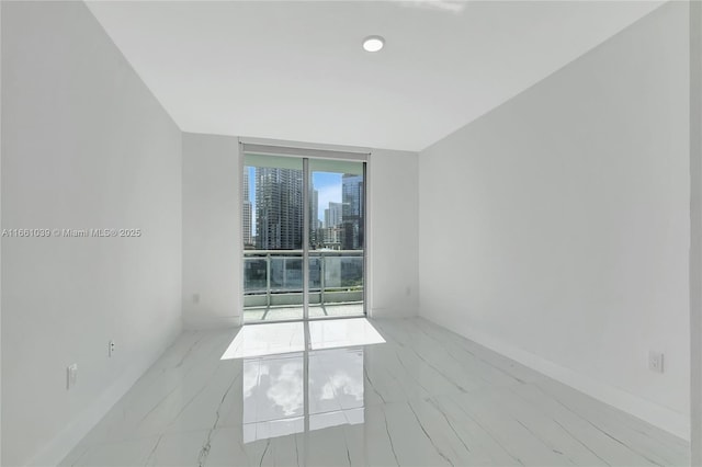 unfurnished room with marble finish floor and a city view