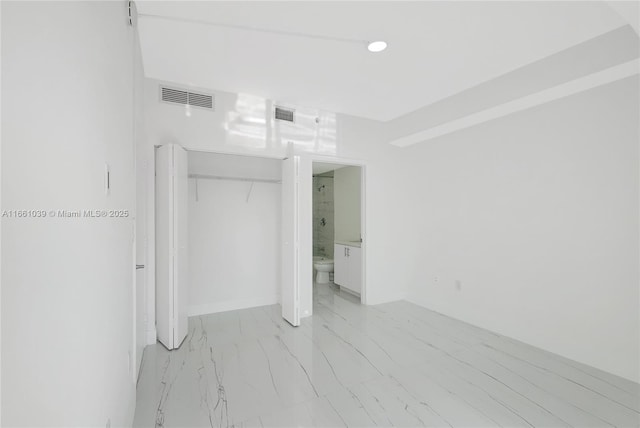 unfurnished bedroom with a closet, visible vents, and marble finish floor