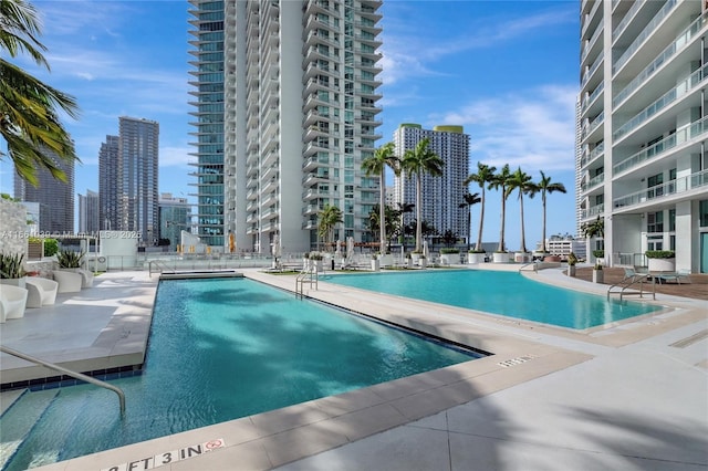 community pool with a view of city and a patio