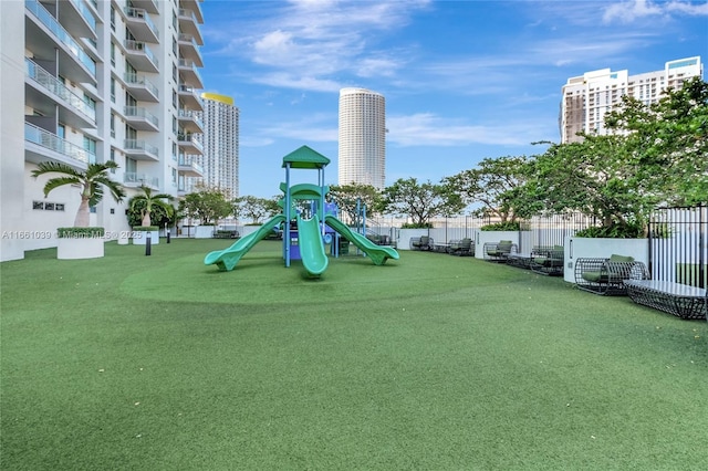 community jungle gym with a city view and fence