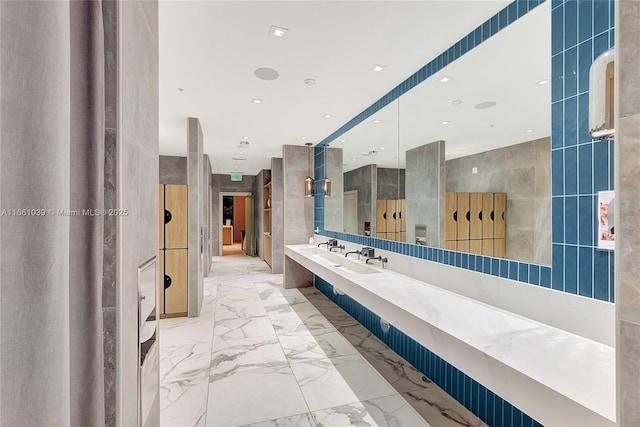 bathroom with recessed lighting, marble finish floor, tile walls, and vanity