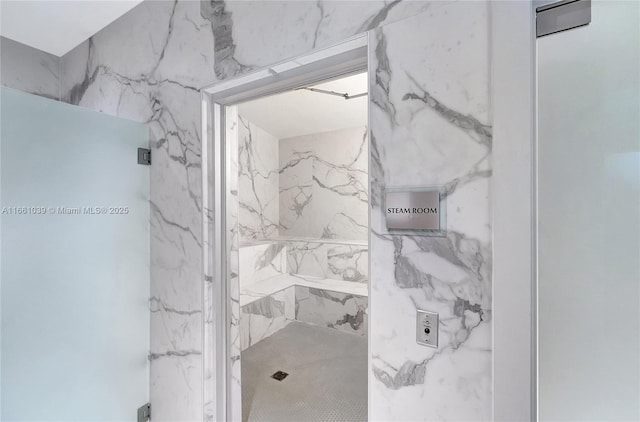 bathroom featuring a marble finish shower