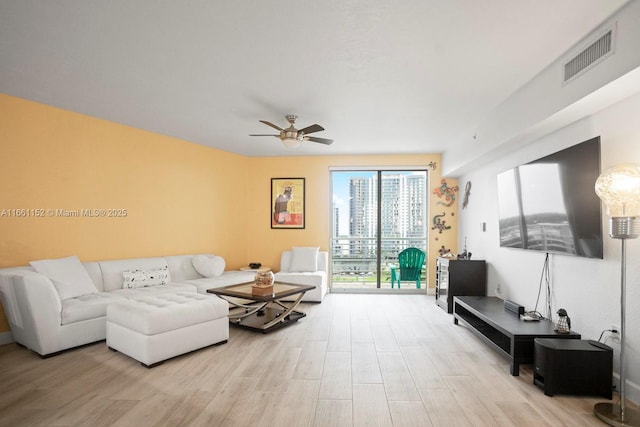 living room featuring ceiling fan and light wood-type flooring