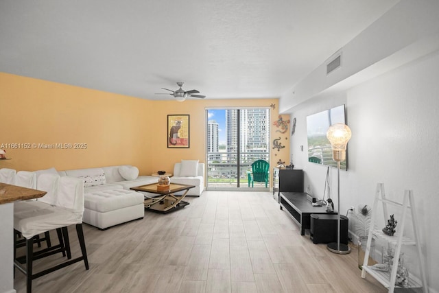 living room featuring light wood-type flooring and ceiling fan